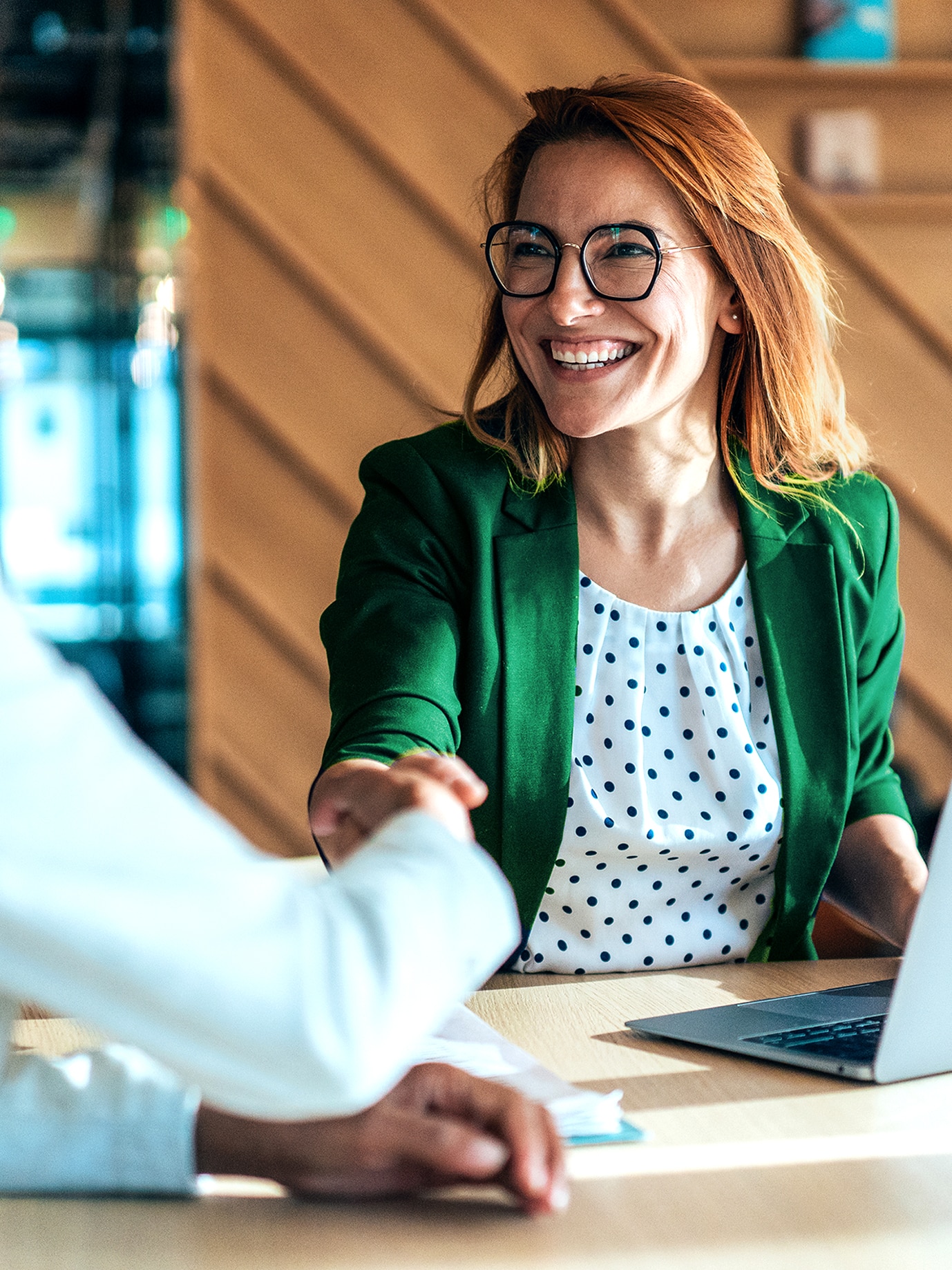 Business professionals shaking hands during a meeting in a modern office