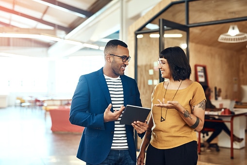 Two professionals engaged in conversation in a modern office